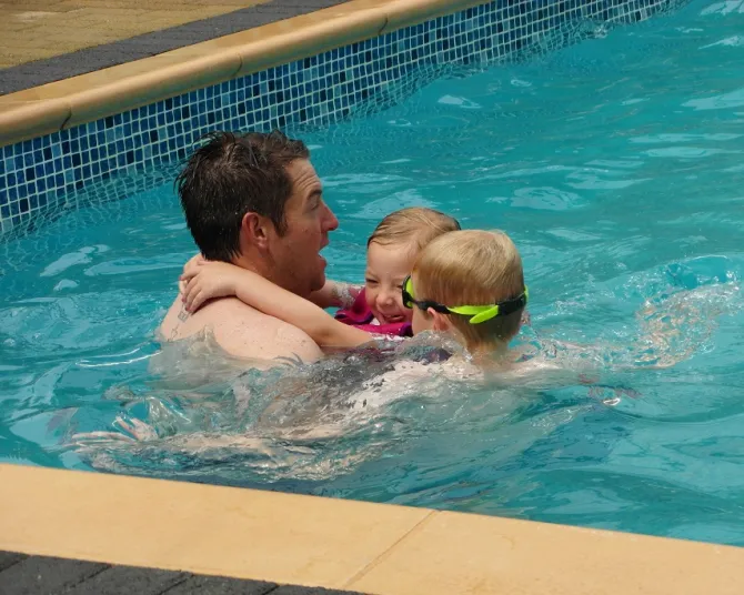 Morfa Bychan father playing with his kids in the pool